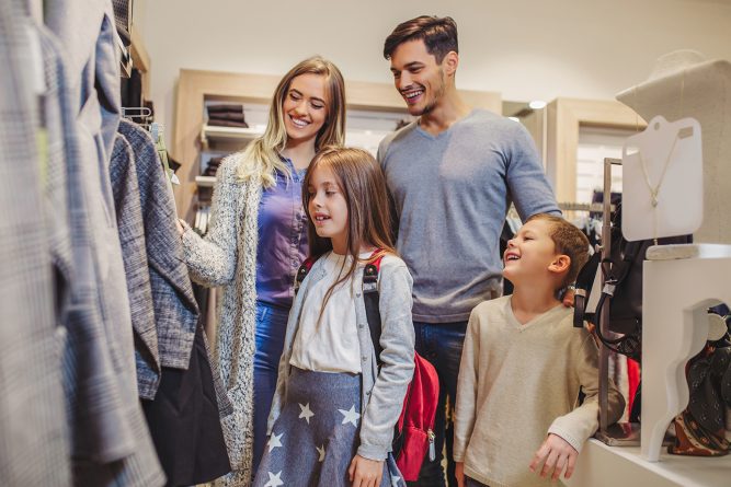 Family shopping for clothes and looking happy