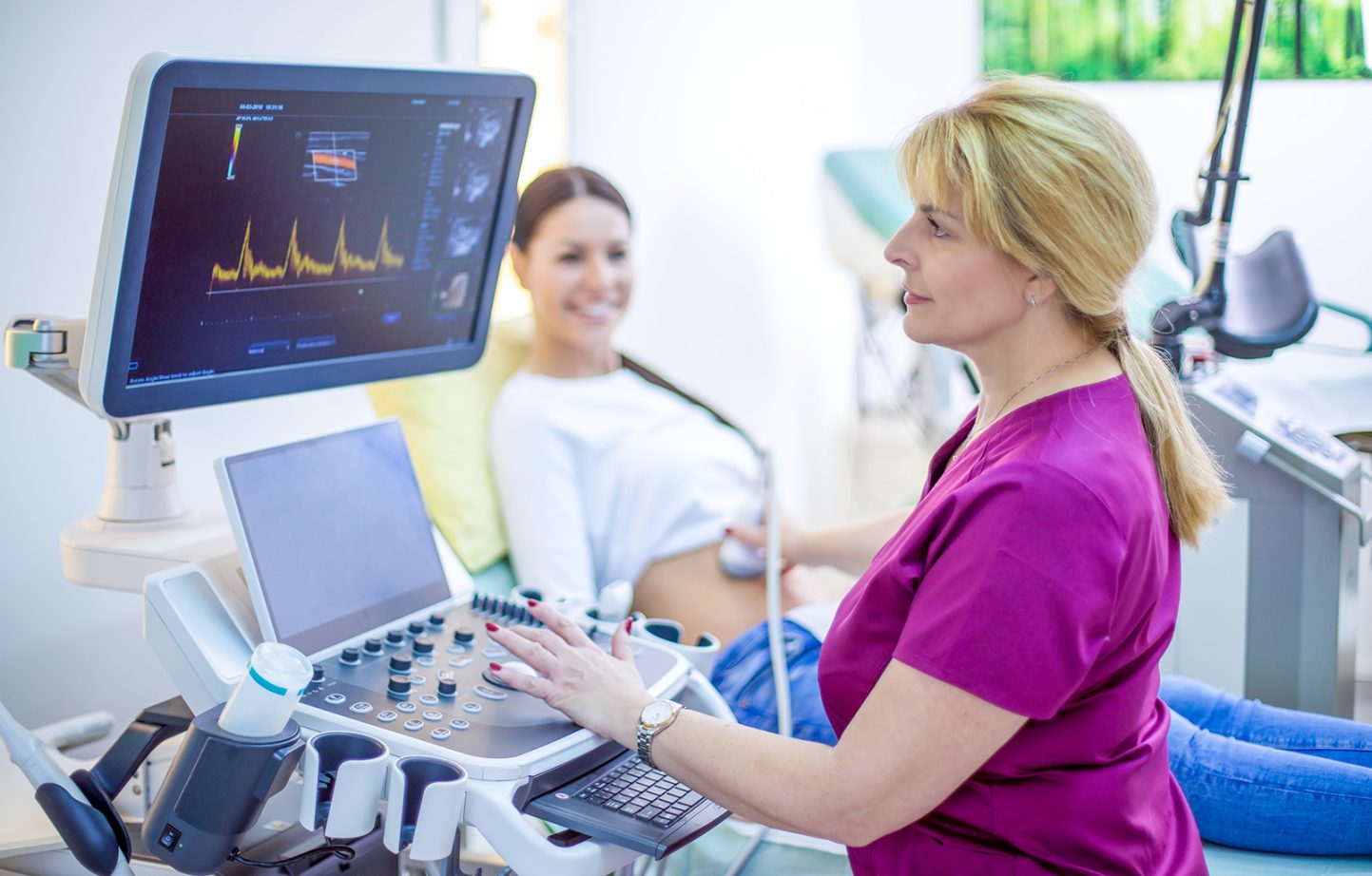 Doctor performing ultrasound on a pregnant woman.